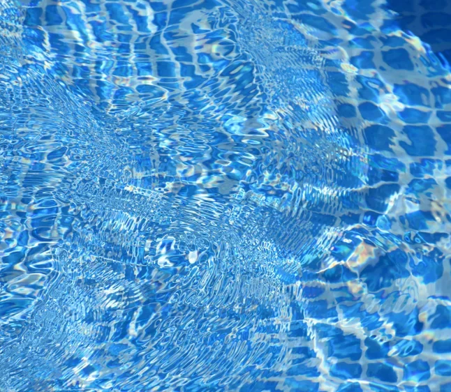 Blue tile pool floor under sparkling water