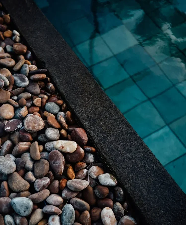 River rock border beside a dark-tile pool in Atascadero