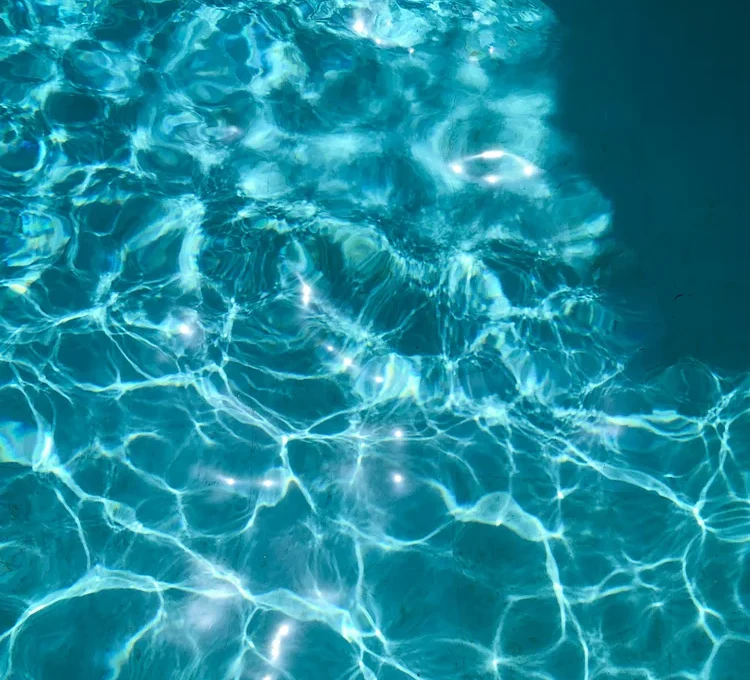 Bright blue pool water rippling in the sun