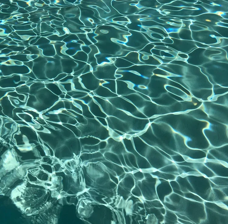 Sunlight shimmering on clear green-blue pool water
