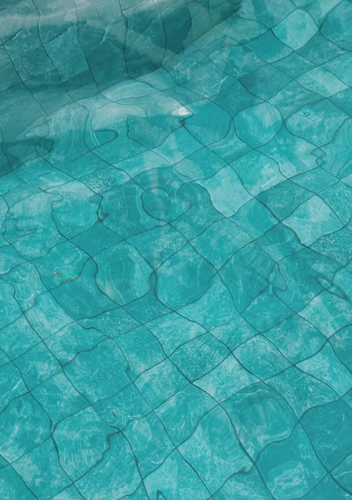 Turquoise pool tile under calm water