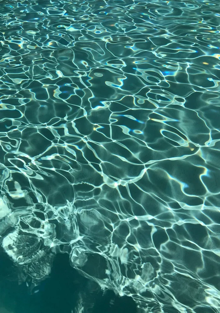 Light reflections on clear turquoise pool water