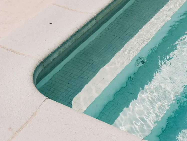 Tiled pool entry step with white coping