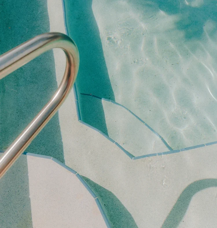 Stainless steel pool handrail over entry steps