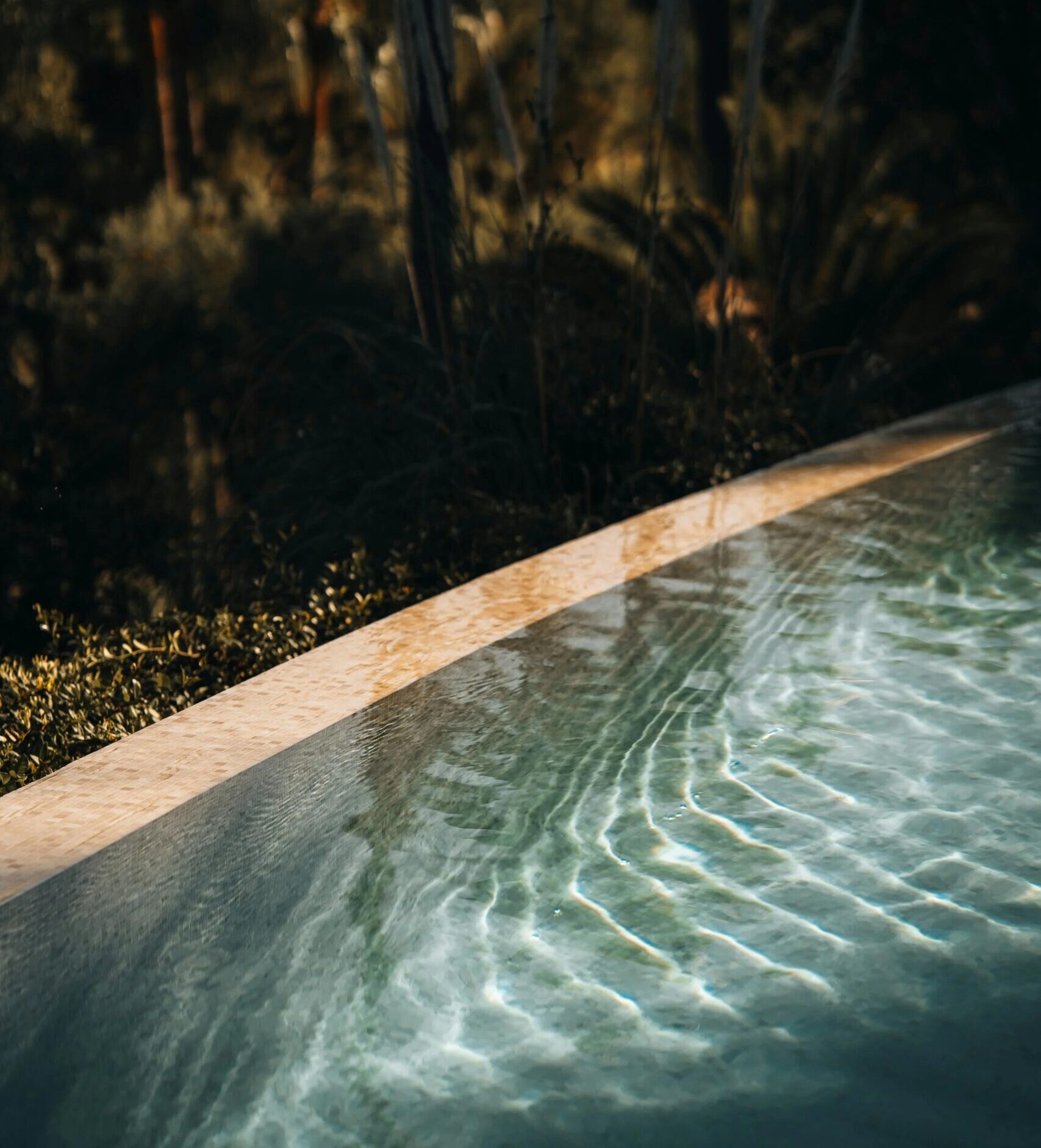 Pool edge at dusk with shimmering water