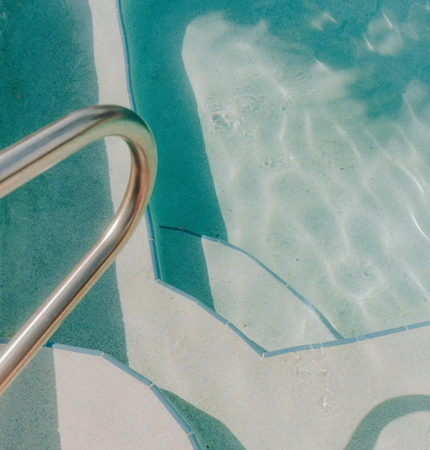 Stainless steel pool ladder in clear water