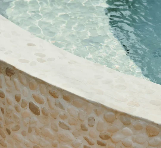 Pebble pool finish below a smooth coping edge