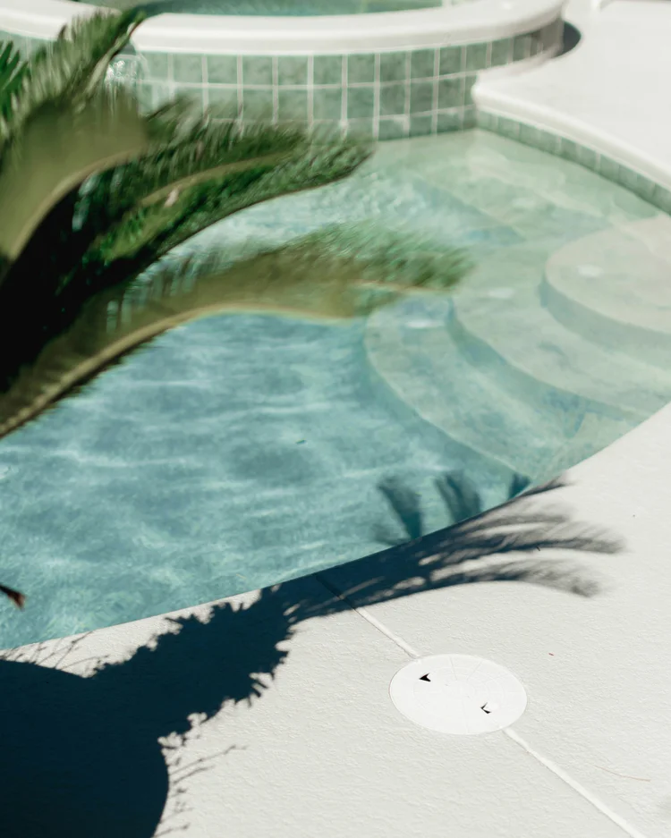 Curved pool and spa with palm frond shadows in Templeton