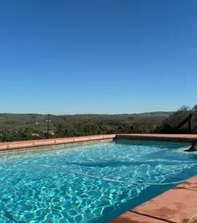 Clean pool with terracotta deck overlooking rolling hills