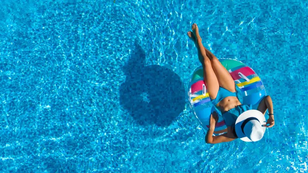 Person relaxing on a float in a clear blue pool